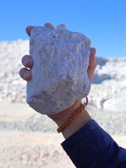 Spodumene ore, lithium bearing mineral, held in hand. Mine, mining of critical minerals, raw materials, for energy transition and storage