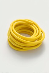 Coiled sample of synthetic rubber tubing in bright yellow color for industrial applications