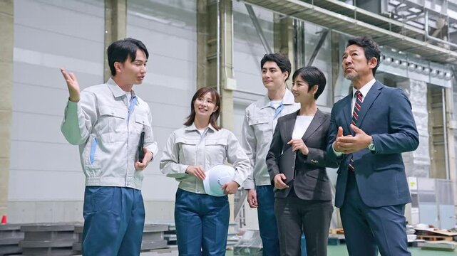 訪問者に工場を案内する男性作業員