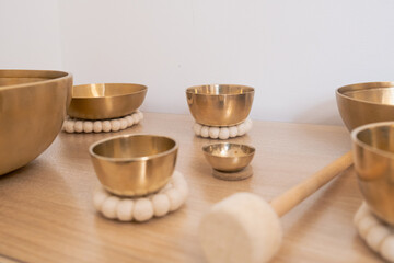 Tibetan singing bowls positioned on a wooden table, used for meditation and sound therapy. Each...
