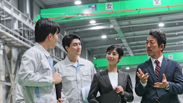 訪問者に工場を案内する作業員