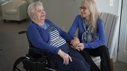 A daughter visits her elderly mother in a cozy home setting, providing care and support while...