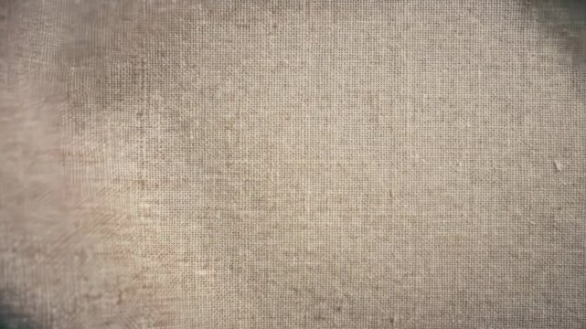 Macro video of textured linen fabric gently fluttering as wind passes