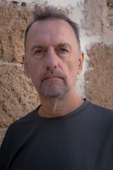 A man between 55 and 60 years old, looking young and calm, looking at the camera.