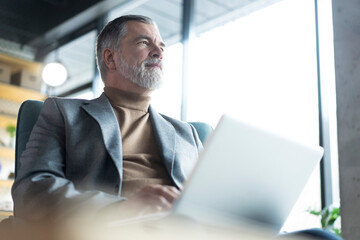 Businessman sitting in office working with laptop computer
