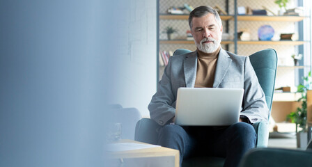 Businessman sitting in office working with laptop computer