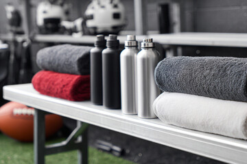 Equipment and towels arranged on a bench in a sports facility during practice session