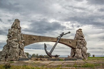Fototapeta premium Large metal anchor displayed under a traditional stone bridge in Guipuzcoa - Spain 
