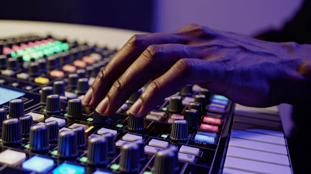 Creative closeup of hand on sound board adjusting knobs highlights artistic process focus detail precise control creative production sound design inspiration
