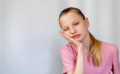 Young Girl with Toothache Holding Cheek. Portrait of a young girl in pink shirt holding her cheek...