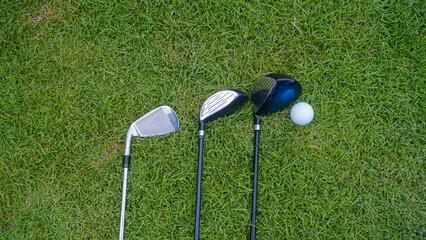 Top view of a golf ball and golf club on green in the evening golf course.