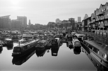 Analog vintage photo of narrowboats moored in london's limehouse basin marina