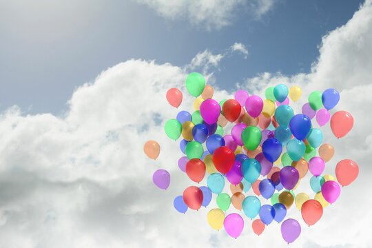 Fototapeta Cluster of multicolored latex balloons rising in partly cloudy blue sky, flat design