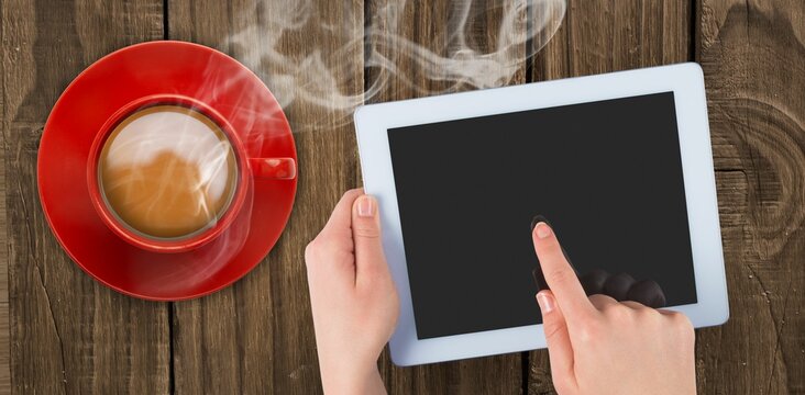 Fototapeta Flat design white tablet is resting in two hands on wooden tabletop with steaming coffee cup