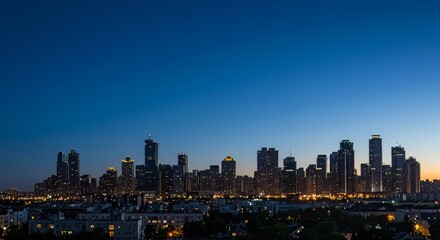 Obraz premium A wide panoramic view of a modern city skyline just after sunset during the blue hour