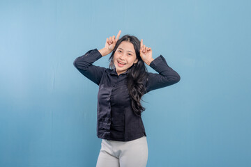 A woman in a black shirt is holding her head and laughing. Concept of humor and lightheartedness