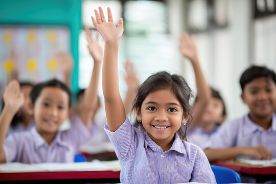 primary school classroom with kids actively raising their hands