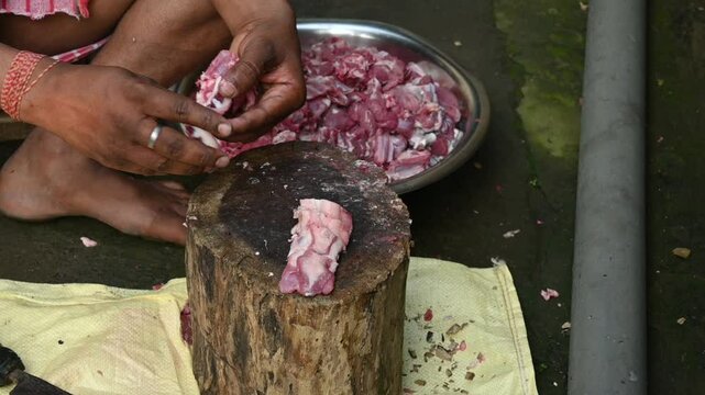 Chopping goat meat. Fresh raw or uncooked goats mutton cutting from Traditional iron tool in Indian village life. chopping goat meat into small pieces. Slow motion video. 
