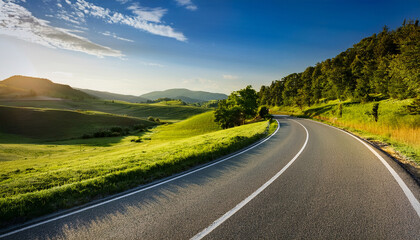 winding asphalt road through a serene and isolated rural landscape with hills and trees in the background rural scenery hills