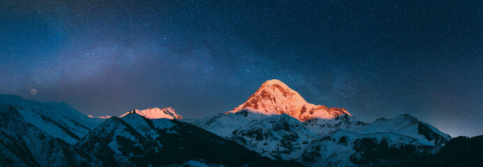Georgia. Mount Kazbek Covered Snow In Winter Sunrise. Morning Dawn Colored Top Of Mountain In Pink-orange Colors. Awesome Winter Georgian Nature Landscape.