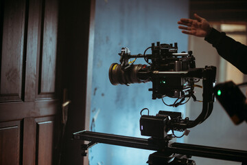 Professional cinema and video camera on the set. Shooting shift, lighting fixtures, shooting equipment and the team. Technique of modern filming and advertising.