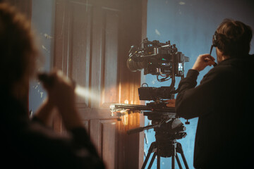 Director of photography with a camera in his hands on the set. Professional videographer at work on...