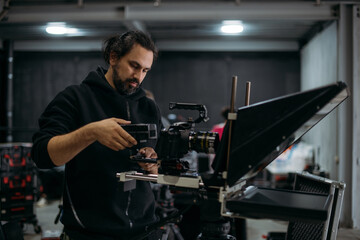 The director of photography with a camera on the set. A professional videographer is working on...