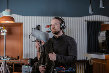 Sound engineer with a microphone on the set. A professional sound engineer at work on the filming...