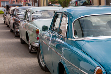 Vintage cars line a picturesque street, showcasing the essence of timeless automotive design and...