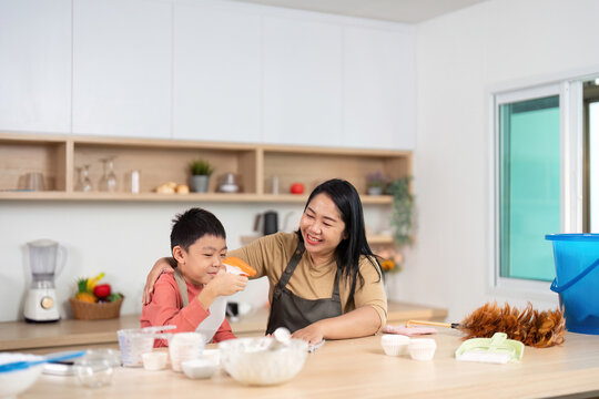 Cleaning and Baking. Engaging mother and son enjoying a fun kitchen moment. - Powered by Adobe