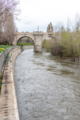 Madrid, Spain - march 20, 2025: Toledo bridge in Manzanares River, on the verge of overflowing in...