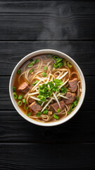 A steaming bowl of delicious vietnamese pho soup with beef and fresh garnishes.