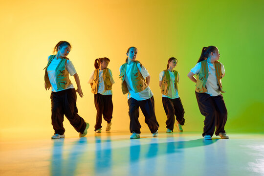 A diverse dance group performs energetic urban choreography in a vibrant studio setting. Concept of multicultural teamwork in performing arts.
