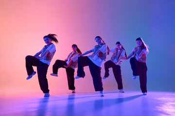 An energetic dance crew performs a synchronized routine under colorful stage lighting. Concept of...