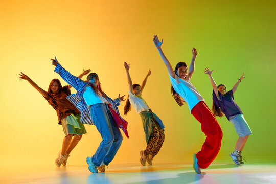 Youthful dancers express energy in a colorful urban dance performance against a vibrant background. Concept of dynamic movement and artistic expression in modern culture. - Powered by Adobe