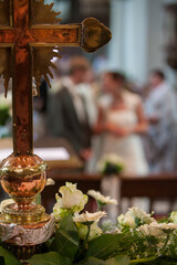 An elegantly beautiful wedding scene showcasing various floral arrangements and a prominent cross as the focal point