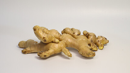 Ginger Root: A close-up view of several fresh ginger root pieces on a table, capturing their natural texture and earthy tones. Perfect for culinary and health-related themes.
