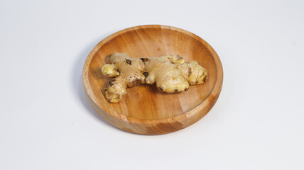 Fresh Ginger on Wooden Plate: A close-up view showcasing the natural beauty of a fresh ginger root elegantly presented on a handcrafted wooden plate.