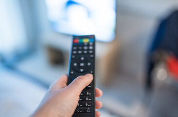 Hand with remote control. Streaming services and watching TV concept.	
