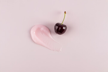 A chic sample of a cosmetic stroke of balm or a lip skin care mask on a pink background with ripe...
