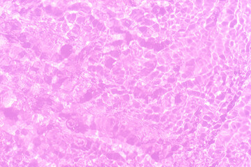 Pink water bubbles on the surface ripples. Defocus blurred transparent pink colored clear calm water surface texture with splash and bubbles. Water waves with shining pattern texture background