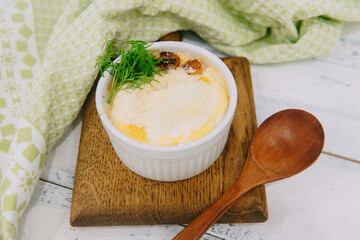 A savory baked casserole meal presented elegantly, topped with garnishes in a styled food...