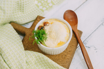 A savory baked casserole meal presented elegantly, topped with garnishes in a styled food...
