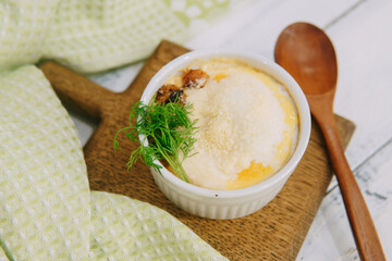 A savory baked casserole meal presented elegantly, topped with garnishes in a styled food...