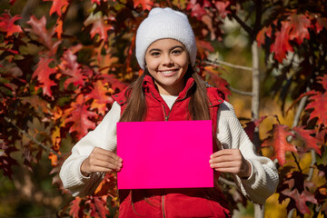 fall time advertisement. suggestion concept. teenager girl suggest something on paper with copy space. autumn girl make a suggestion. girl suggest fall season sale. suggest for this autumn