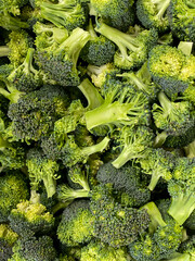 Fresh raw green broccoli florets in bulk, ideal for healthy cooking and meal prep.