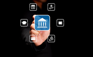 A person interacts with digital banking icons floating around a central bank symbol on a dark...