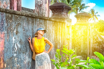 A woman posing near a wall of ancient ruins in Nha Trang, Vietnam - a moment of silence amidst the historical heritage and nature of Southeast Asia. Tourism concept