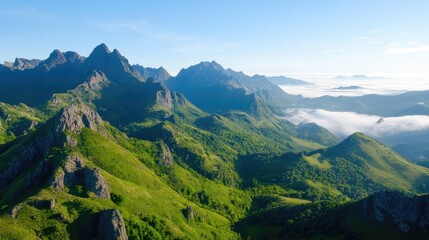 Panoramic view of a mountain range. Lush green valleys and peaks pierce a hazy sky
