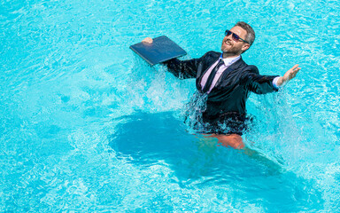 Business retreat. Happy businessman on summer vacation. Freelancer has remote work online. Businessman in suit with laptop at swimming pool. Successful freelancer. Business trip success, copy space